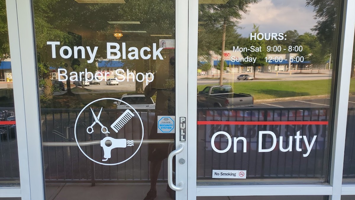 Tony Black Barber Shop front door with the scissors and comb logo