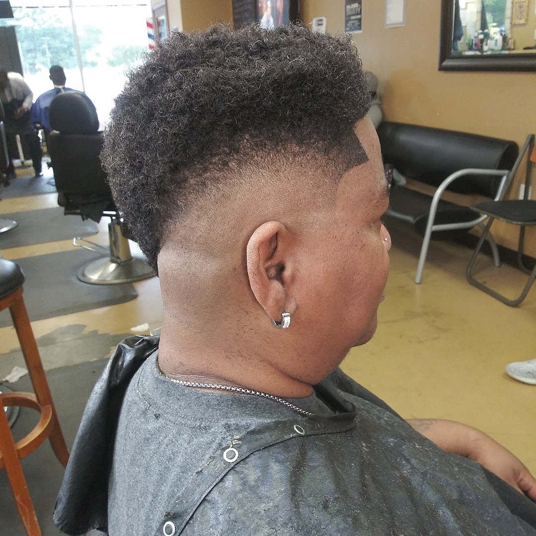 Clean burst fade with a crisp line-up, side profile, at Tony Black Barbershop in Stockbridge, GA